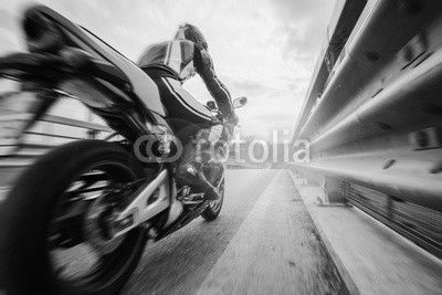 Moto da strada sfreccia vicino al guard rail al tramonto