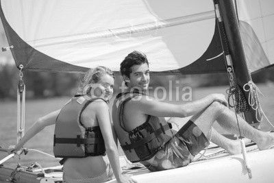 young couple steering a catamaran
