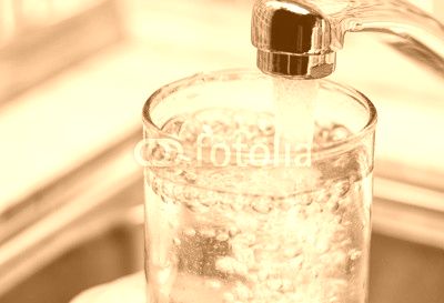 Filling up a glass with drinking water from kitchen tap