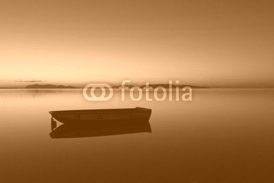 A warm sunset on a calm water, with Islands in the background