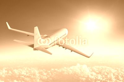Airliner flying towards the sun in blue sky