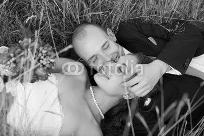 Bride and groom lying on green grass