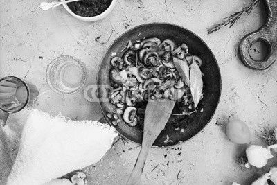 Fried mushrooms cast-iron pan on table.