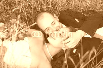 Bride and groom lying on green grass