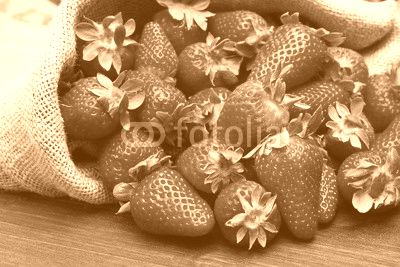 fresh strawberry in burlap sack on wood