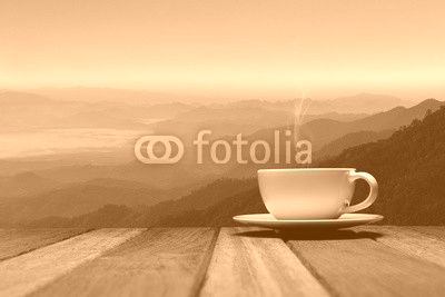 Morning cup of coffee or tea with mountain background at sunrise