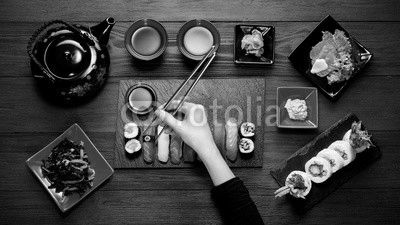 Woman eating sushi with chopsticks top view