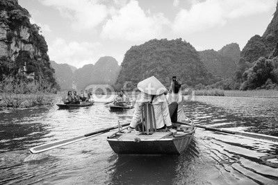 Tourists in boats. Rowers using feet to propel oars, Vietnam