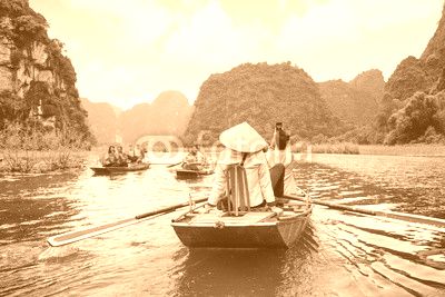 Tourists in boats. Rowers using feet to propel oars, Vietnam