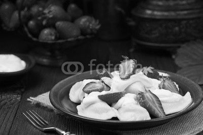 Delicious dumplings with fresh strawberries served with whipped cream and sugar.
