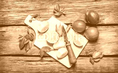 Sliced limes on a wooden board with leaves and knife.