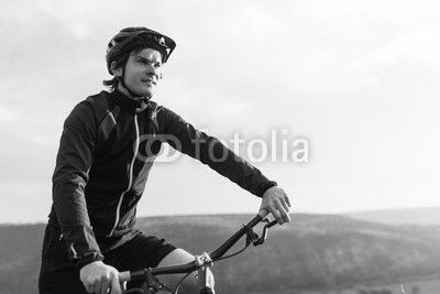 Young male riding bicycle among mountains