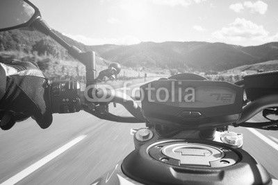 Motorradfahrer fährt auf Straße im Sommer