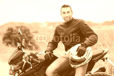 handsome young man biker with white helmet riding black motorcycle