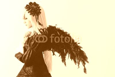 Cosplay girl with white hair , black wings , in a black dress with colored eyes in ryushah and decorations in the studio during the day .