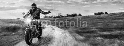 Motorrad fährt auf freier Landstrasse in den Sonnenuntergang