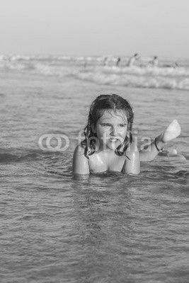 Girl swiming and playing in the seashore of the beach