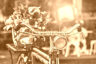 close up vintage bicycle with bouquet flowers in basket in vintage tone style