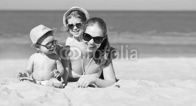 Happy family mother and children play and laugh on beach
