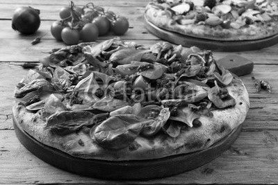 pizza vegetariana con spinaci e pomodori freschi su sfondo rustico