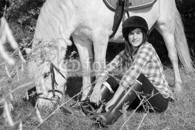 Portrait of a pretty young woman with white horse riding