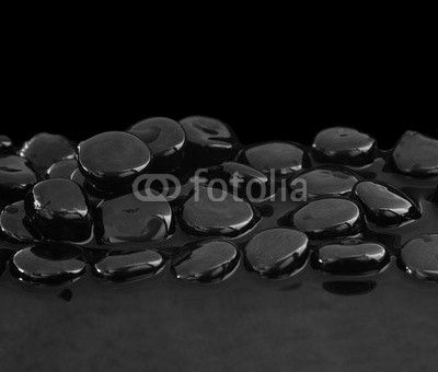 Black stones on calm water background