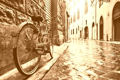 Retro vintage red bike on cobblestone street in the old town. Color in black and white