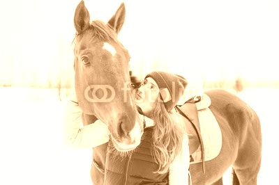 Female rider and horse in the open air. portrait of a beautiful young woman with her stallion, outdoors in winter. girl hugging and caressing the animal