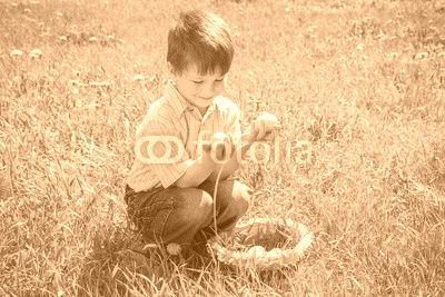 little kid with colorful easter eggs on green lawn