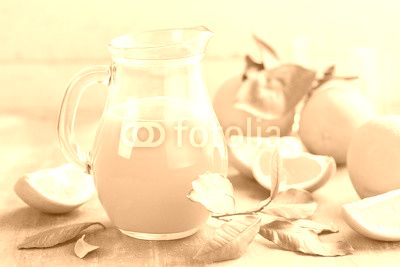Orange juice in glass and fresh fruits with leaves on wooden background, vitamin drink or cocktail
