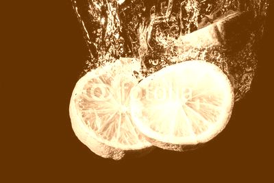 Lemon slice splashing into water.