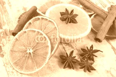 Dried and fresh orange with spices on old wooden background