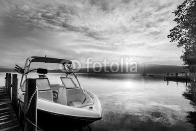 Sun and mist on boat dock at sunrise on a summer day. Merrymeeting Lake, New Hampshire