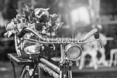 close up vintage bicycle with bouquet flowers in basket in vintage tone style