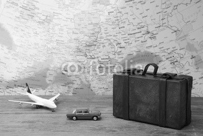 Trip or traveling by airplane concept. Miniature toy airplane and suitcases on map.