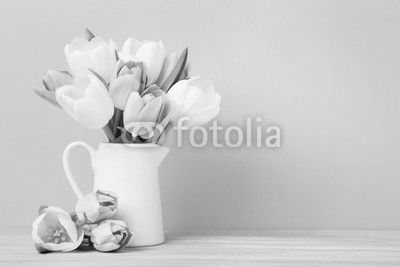 Bouquet of tulips in jug on green background
