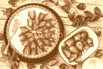 Delicious sponge cake with fresh strawberries on a wooden background.
