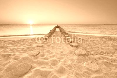 lange hölzerne Buhnen am Strand, Sonnenuntergang am Meer