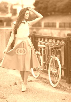 Young beautiful, elegantly dressed woman with bicycle