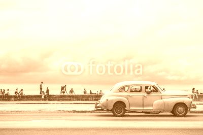 HAVANA, CUBA - MAY 18, 2011: Classic vintage American car serving as taxi drives along the seafront Malecon, a popular place for socializing in Central Havana.