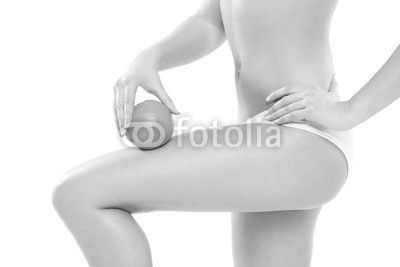 Young woman in underwear holding an orange showing absence of ce