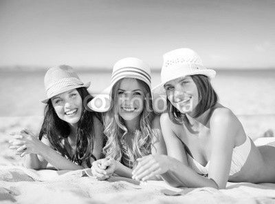 happy young women in bikinis on summer beach