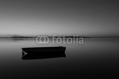 A warm sunset on a calm water, with Islands in the background