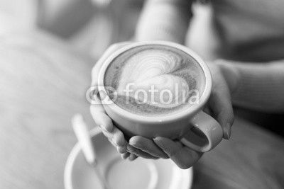 lady's hands holding cup with sth heart-shaped