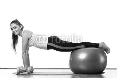 woman with gym ball and dumb bells isolated