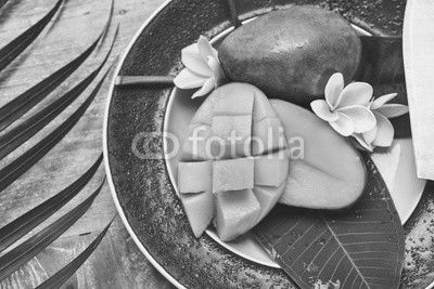 Fresh mango on a wooden tabel with tropical background. Soft focus.