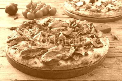 pizza vegetariana con spinaci e pomodori freschi su sfondo rustico