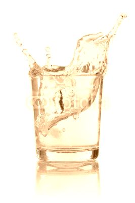 Eiswürfel fällt in ein Glas mit Wasser
