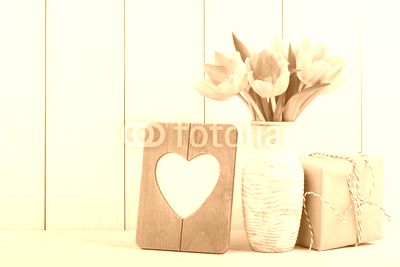 Fresh pink tulips, blank frame and gift box
