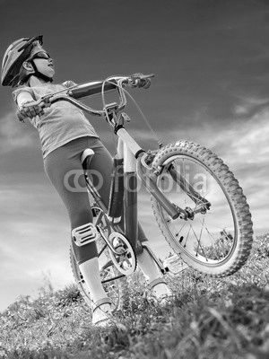 Child traveling bicycle in summer park. Children road bike for running on green grass. Bottom view aganist sky blue. Cycling trip is good for health.